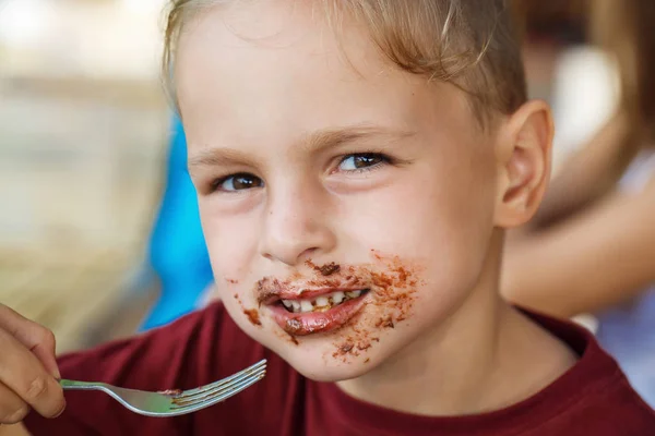 Ragazzo mangiare pancake con banana e cioccolato — Foto Stock