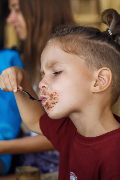 Boy eating pancake with banana and chocolate — Stock Photo, Image