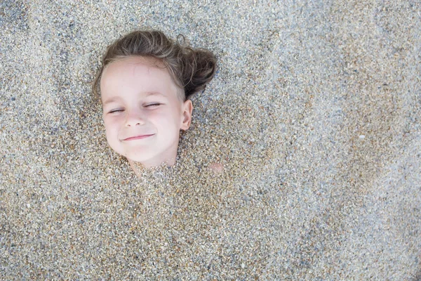 Junge versteckt im Sand am Strand — Stockfoto