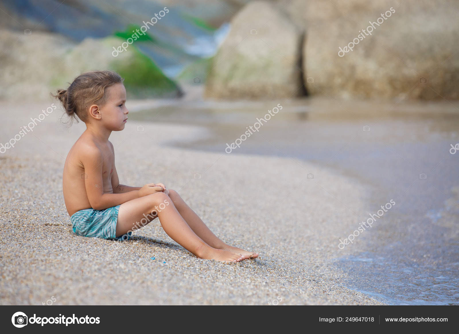 Boy sitting on the sand by the sea Stock Photo by ©gorov108 249647018