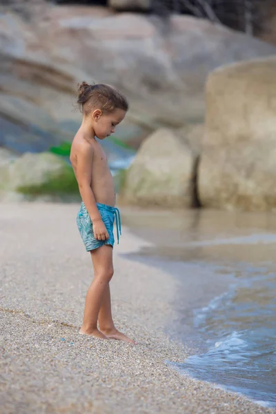 Chłopiec stoi na piasku nad morzem — Zdjęcie stockowe