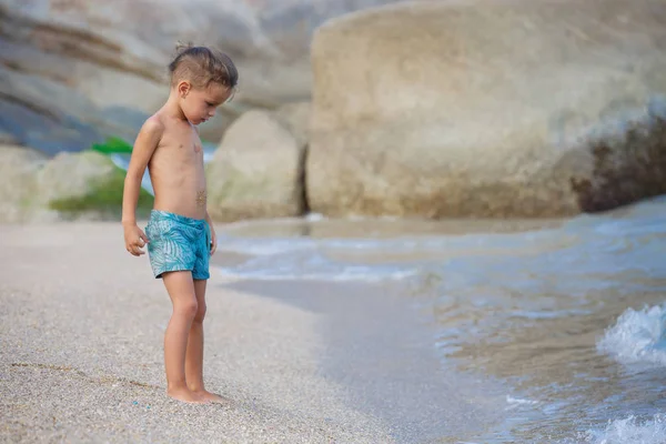 Menino de pé na areia junto ao mar — Fotografia de Stock