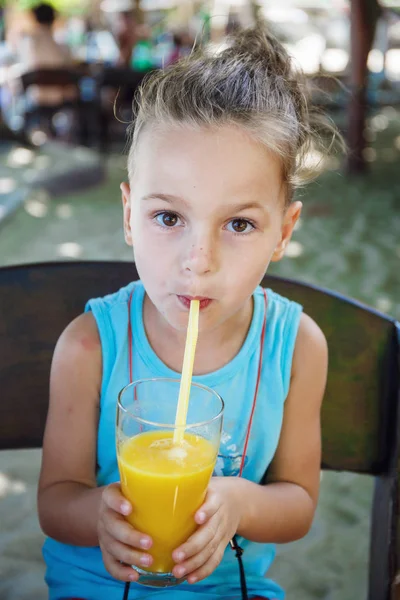 Beautiful boy is drinking orange juice — Stock Photo, Image