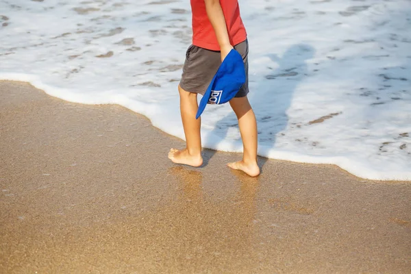 Piccole gambe di un ragazzo che cammina sulla spiaggia — Foto Stock