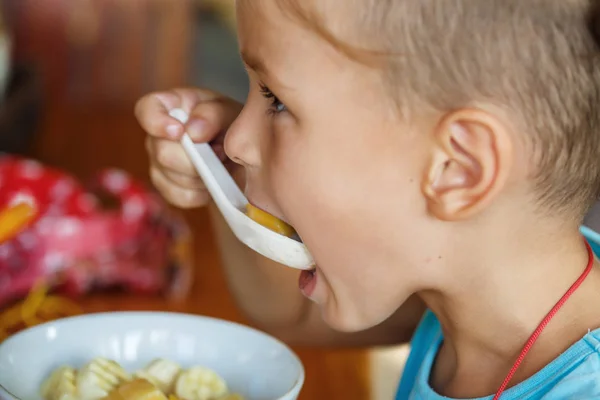 Beautiful boy is having breakfast with  porridge — Stock Photo, Image