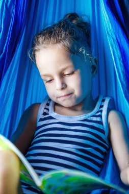 bir hamakta bir kitap okuma yakışıklı çocuk