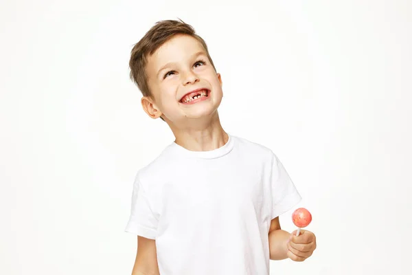 Liten pojke med en slickepinne på vit bakgrund — Stockfoto