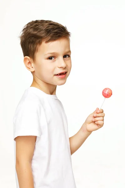 Kleine jongen met een lolly op een witte achtergrond — Stockfoto