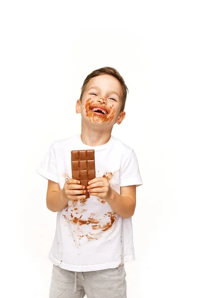 Маленький брудний хлопчик їсть шоколадний студійний знімок — стокове фото