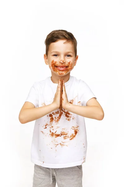 Kleine jongen met gezicht en handen in chocolade — Stockfoto