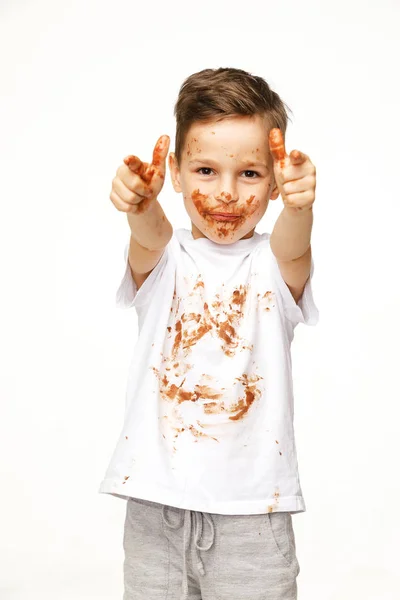 Menino com rosto e mãos em chocolate — Fotografia de Stock