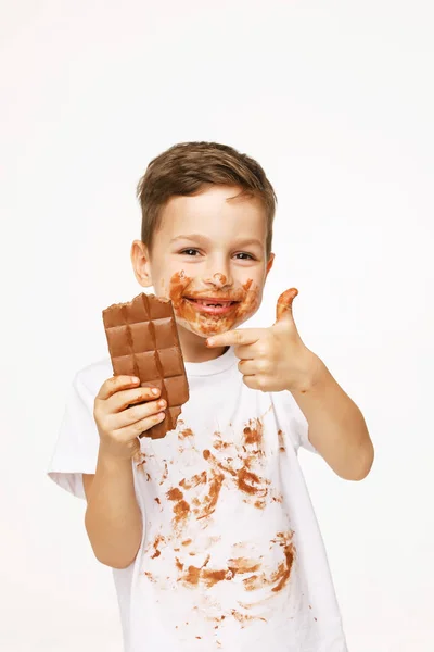 Kleine jongen met gezicht en handen in chocolade — Stockfoto