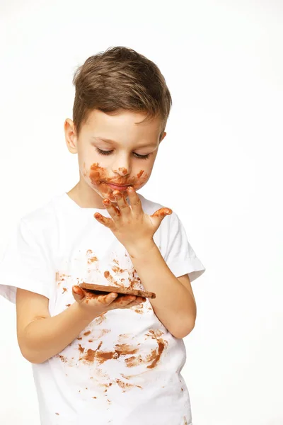 Kleine jongen met gezicht en handen in chocolade — Stockfoto