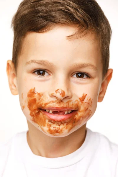 Little boy with face and hands in chocolate — Stock Photo, Image