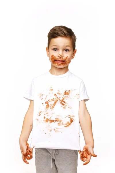 Маленький мальчик с лицом и руками в шоколаде — стоковое фото