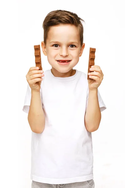Pequeño hermoso chico sosteniendo chocolates studio shot — Foto de Stock