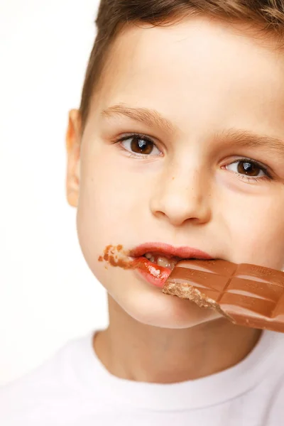 Kleine mooie jongen eten chocolade Studio geschoten — Stockfoto