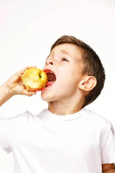 Menino está comendo maçã estúdio tiro — Fotografia de Stock