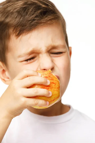 Маленький хлопчик їсть яблуко з зубним болем — стокове фото