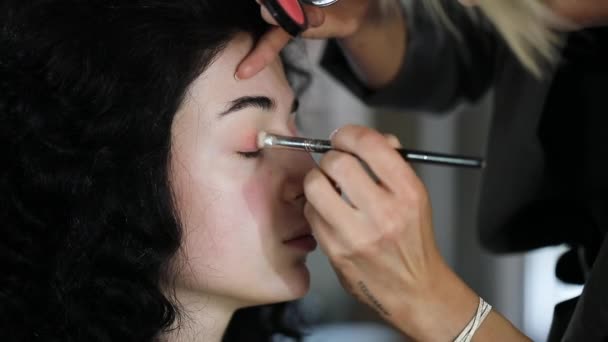 Magnifique modèle brune lors d'une séance photo en attendant l'achèvement du maquillage . — Video