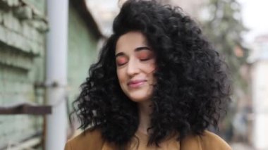 Afro saç modeli ile güzel esmer. Gülümsüyor, gülüyor, ve kafasını çatlaklar.