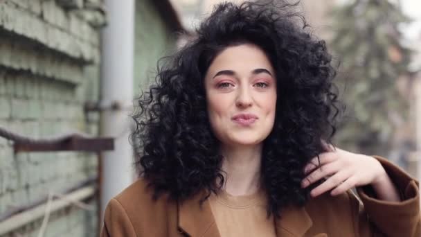 Afro saç modeli ile güzel esmer. Gülümsüyor, gülüyor, ve kafasını çatlaklar. — Stok video