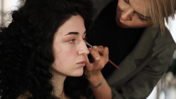 Schönes brünettes Modell bei einem Fotoshooting, das auf die Fertigstellung des Make-ups wartet. — Stockvideo