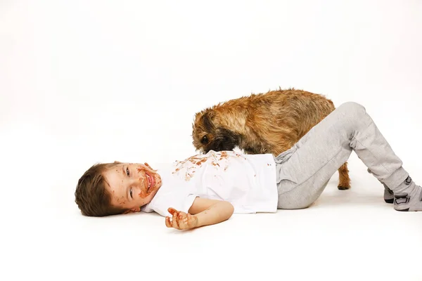 Mały chłopiec w czekoladzie z psem — Zdjęcie stockowe