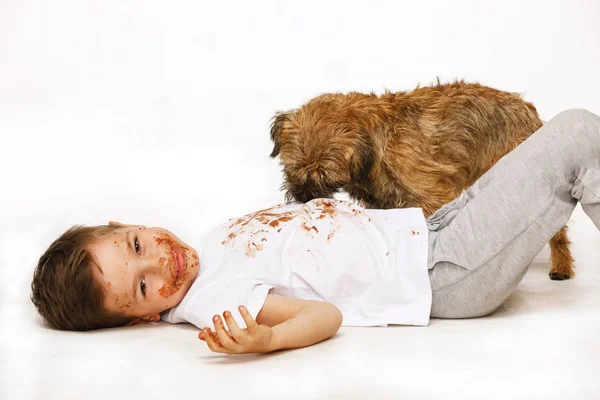 Menino em chocolate com seu cão — Fotografia de Stock