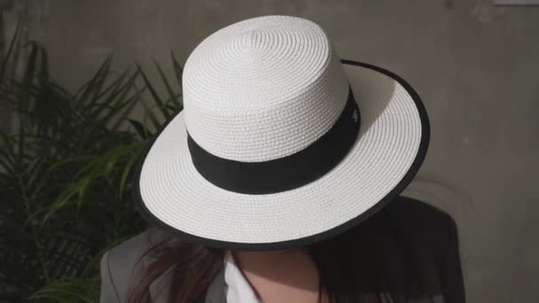 Beautiful young brunette in an elegant hat and business suit. — Stock Video