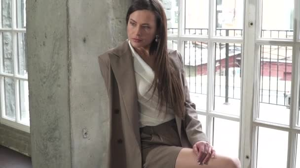 Schöne junge Brünette in einem Business-Anzug. posiert bei einem Fotoshooting — Stockvideo