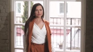 İş elbisesi içinde güzel genç esmer. Fotoğraf çekiminde poz verme