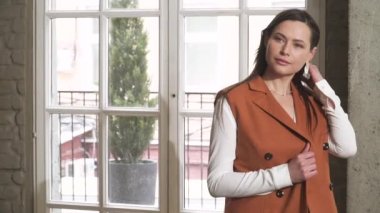 İş elbisesi içinde güzel genç esmer. Fotoğraf çekiminde poz verme