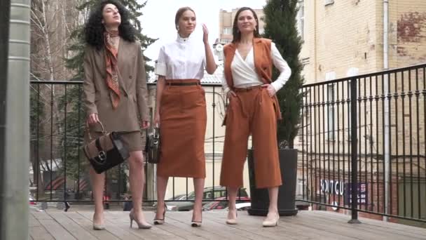 Three beautiful young girls in business suits. Business style. — Stock Video