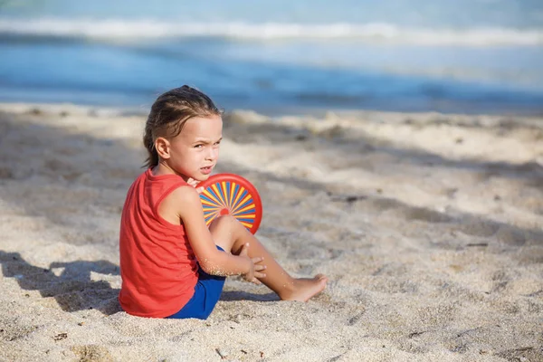 Mignon garçon jouer frisbee sur l 'plage — Photo