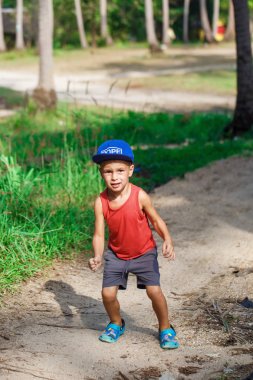 kırmızı tişörtlü ve gri şortlu çocuk