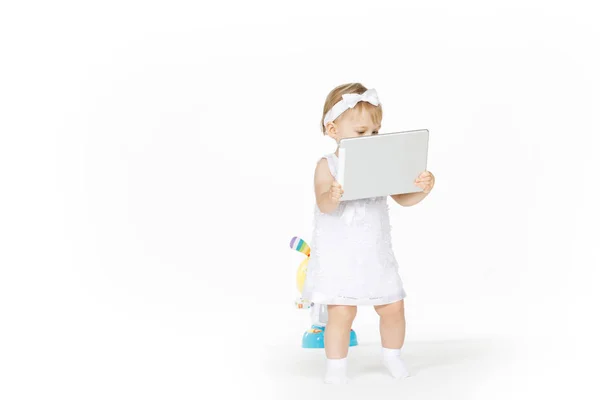 Niña todo en blanco con tableta y juguete — Foto de Stock