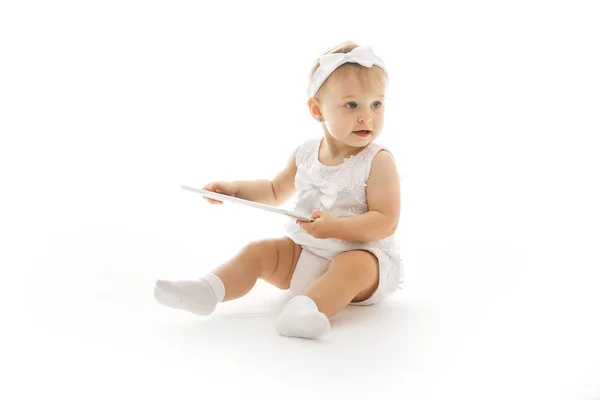 Маленькая девочка в белом с планшетом — стоковое фото