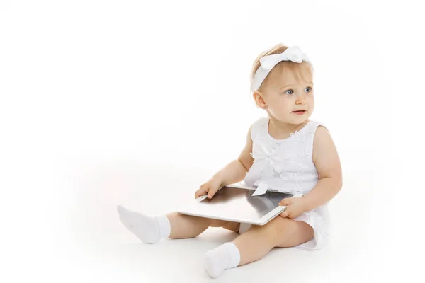 Маленькая девочка в белом с планшетом — стоковое фото