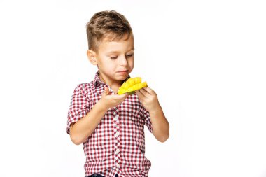 kırmızı bir gömlek yakışıklı çocuk bir mango yiyor