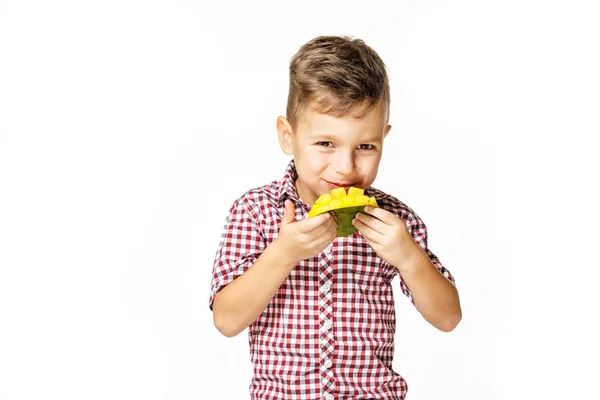 Fešák v červené košili žere mango — Stock fotografie