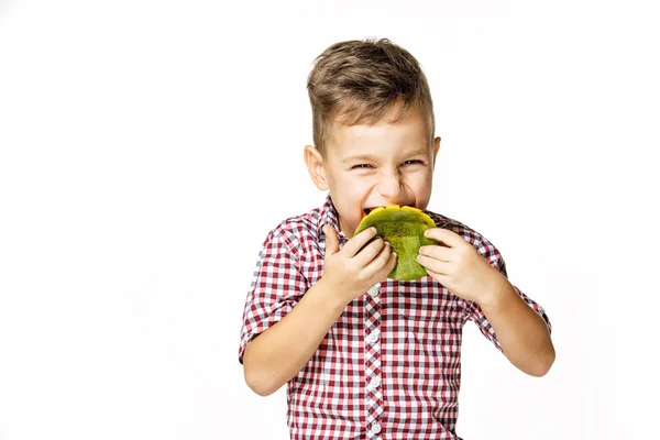 Красивий хлопчик в червоній сорочці їсть манго — стокове фото