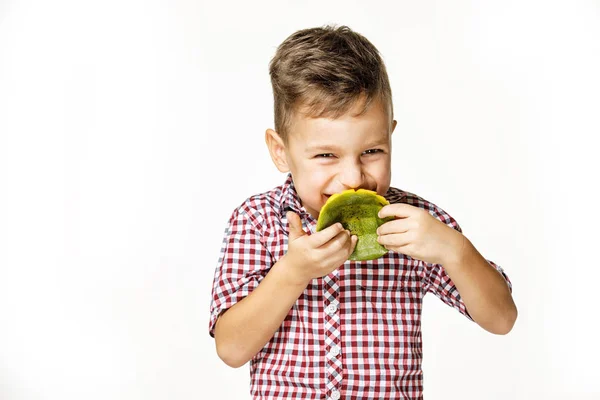 Bello ragazzo in un rosso camicia è mangiare un mango — Foto Stock