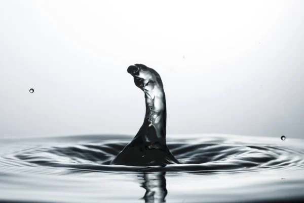 Drop of water falling down in the water — Stock Photo, Image