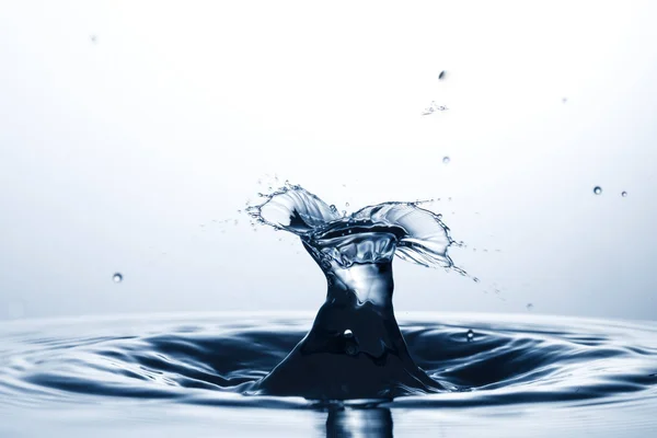 Drop of water falling down in the water — Stock Photo, Image