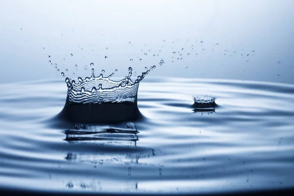 Капля воды, падающая в воду — стоковое фото