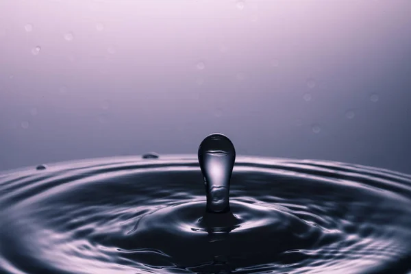Wassertropfen fallen ins Wasser — Stockfoto