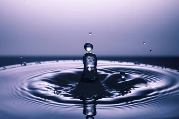 Gota de água caindo na água — Fotografia de Stock