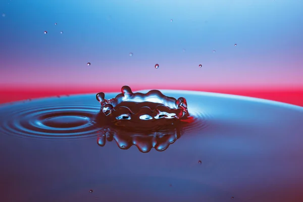 Droppe vatten faller ner i vattnet — Stockfoto