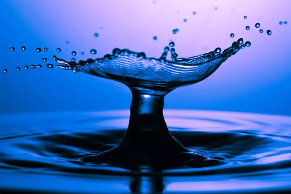 Drop of water falling down in the water — Stock Photo, Image